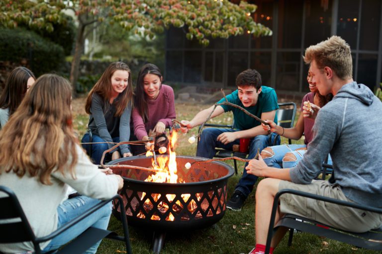 young people learning how too use fire pit