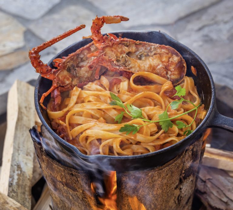 swedish torch being used to cook food of lobster and pasta