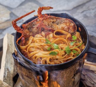 swedish torch being used to cook food of lobster and pasta